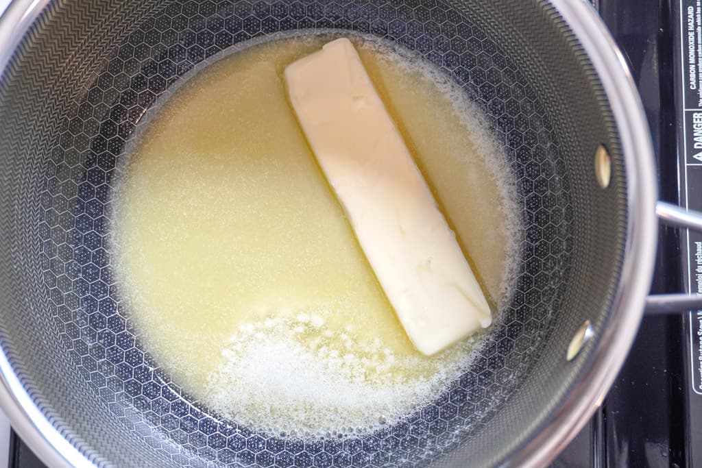 a stick of butter melting in a pot