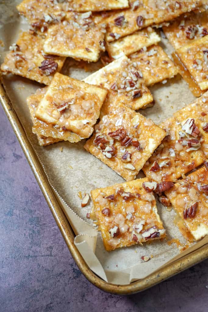 praline crackers on a parchment lined baking sheet