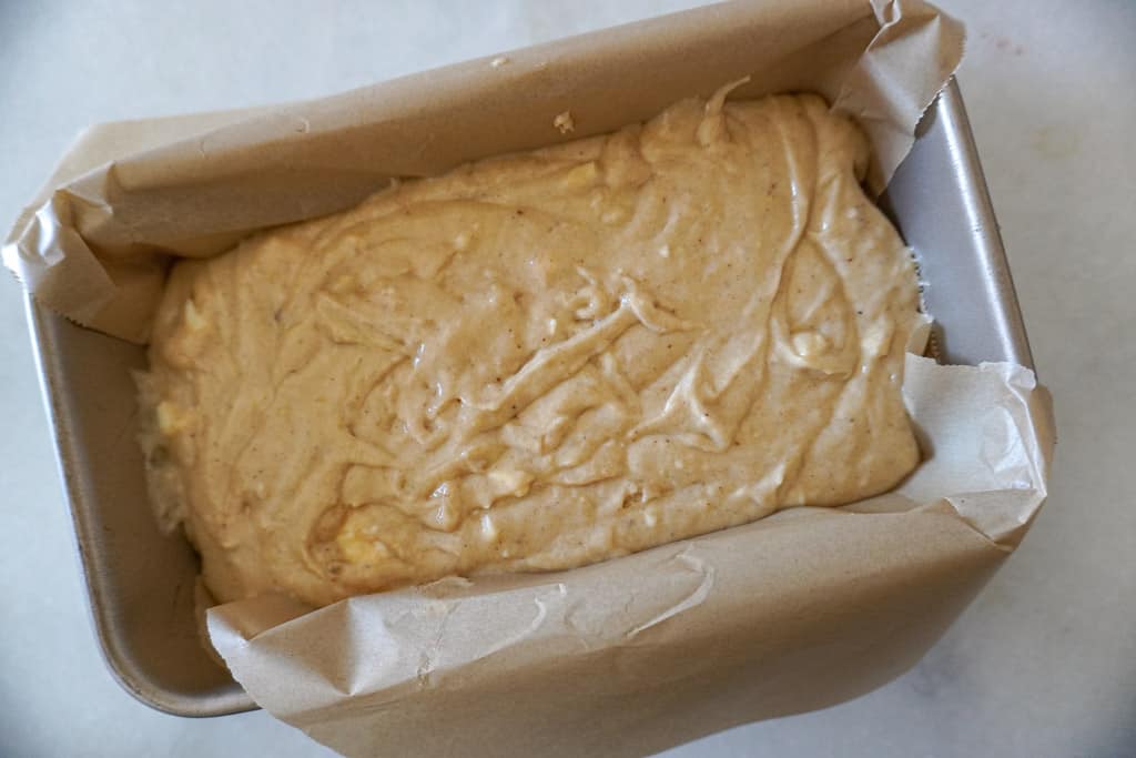 banana bread batter in a parchment paper lined loaf pan
