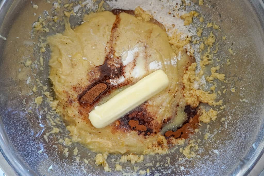 a bowl containing mashed bananas, flour, baking powder, salt, butter, and sugar before mixing