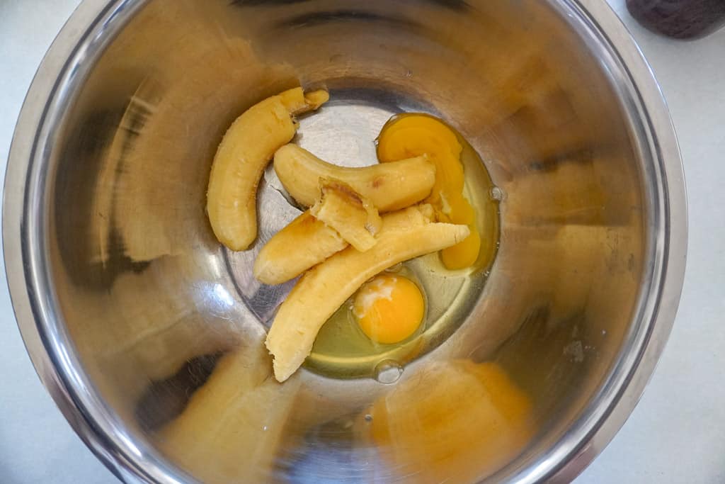 a bowl of ripe bananas and two raw eggs