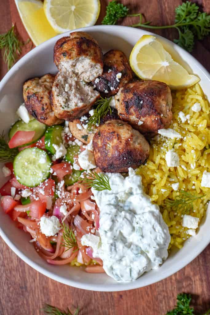 a rice bowl with greek chicken meatballs