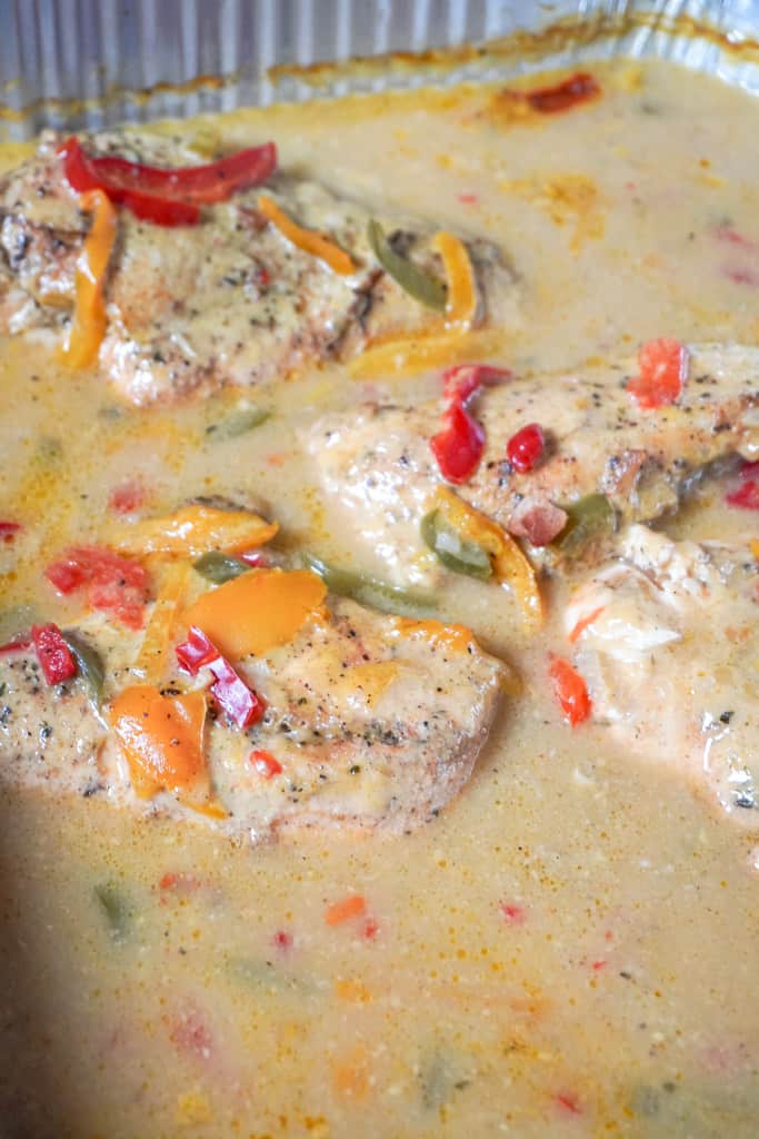chicken breasts in soup mixture in a pan