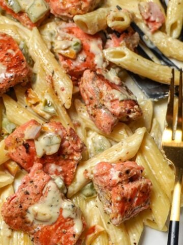 close up view of a plate of lemon pepper salmon with pasta