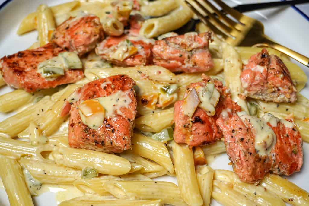 close up view of a plate of lemon pepper salmon with pasta
