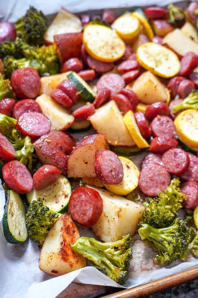 close up view of Sausage and Veggies on parchment-lined sheet pan