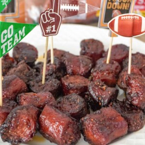 A plate of BBQ hot dog burnt ends garnished with football-themed toothpick toppers, ready for serving.