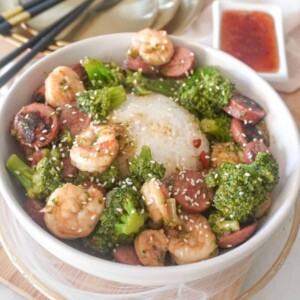 shrimp and broccoli with sausage in a bowl with rice