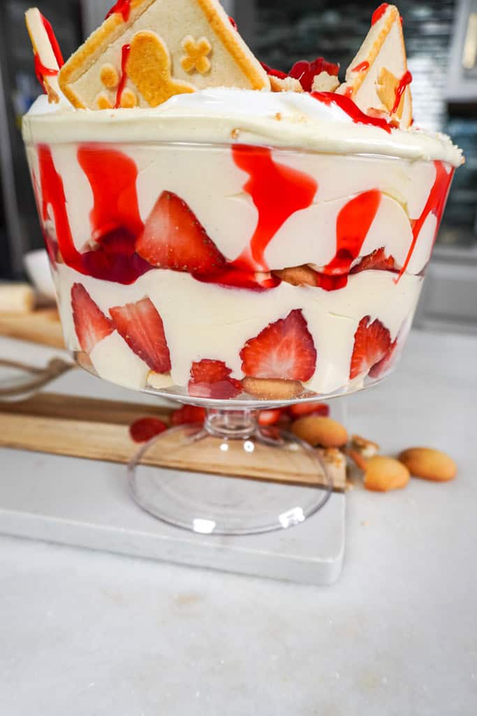 strawberry banana pudding A clear trifle dish showcasing colorful layers of pudding, fresh strawberries, bananas, and cookies.