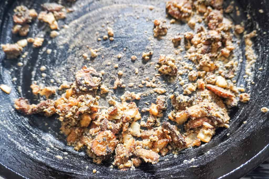 A cast iron skillet with browned bits and seasonings, the base for a flavorful homemade gravy.