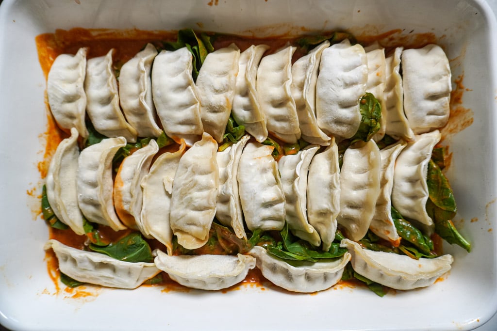 baked dumplings in a dish with green onions on top