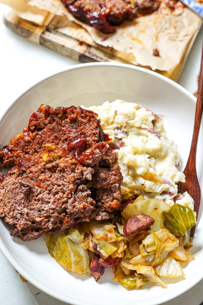 meatloaf plated with cabbage and mashed potatoes