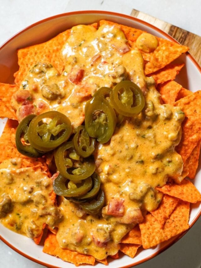 rotel dip with ground beef on a bed of doritos topped with jalapenos