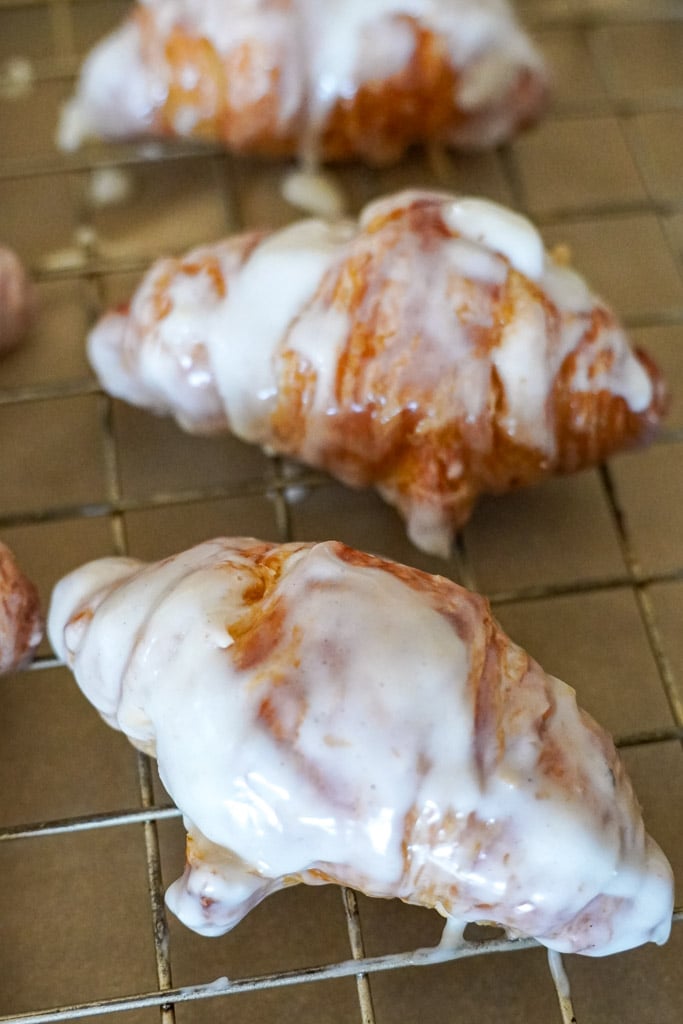 glazed croissants on a cooling rack