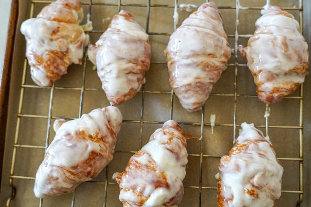 glazed croissants on a cooling rack