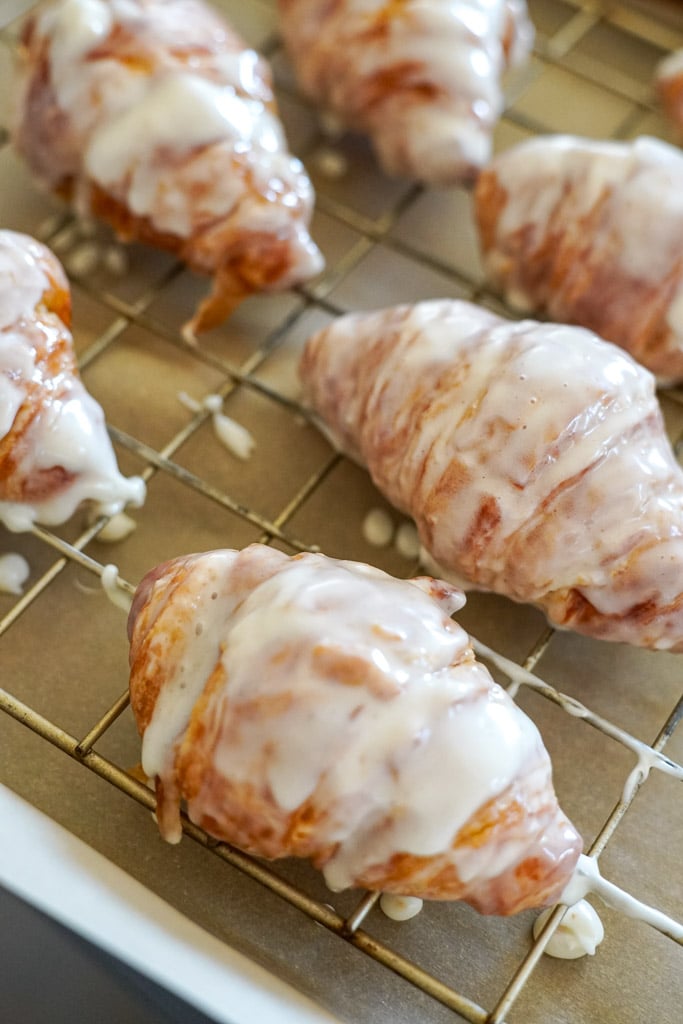 glazed croissants on a cooling rack