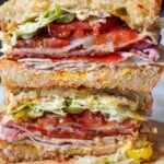 close up of a turkey, ham, and cheese sandwich stacked on top of each other