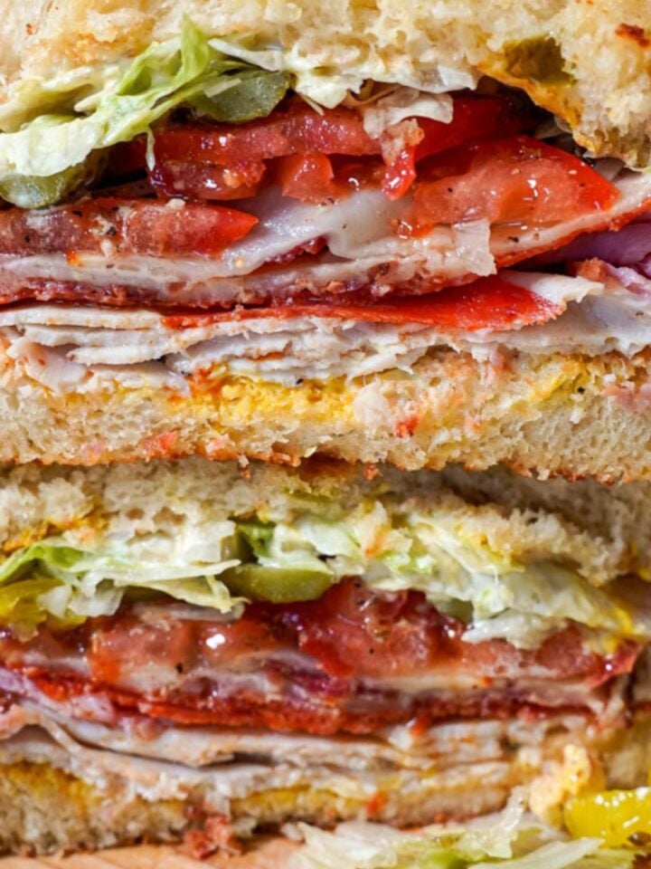 close up of a turkey, ham, and cheese sandwich stacked on top of each other