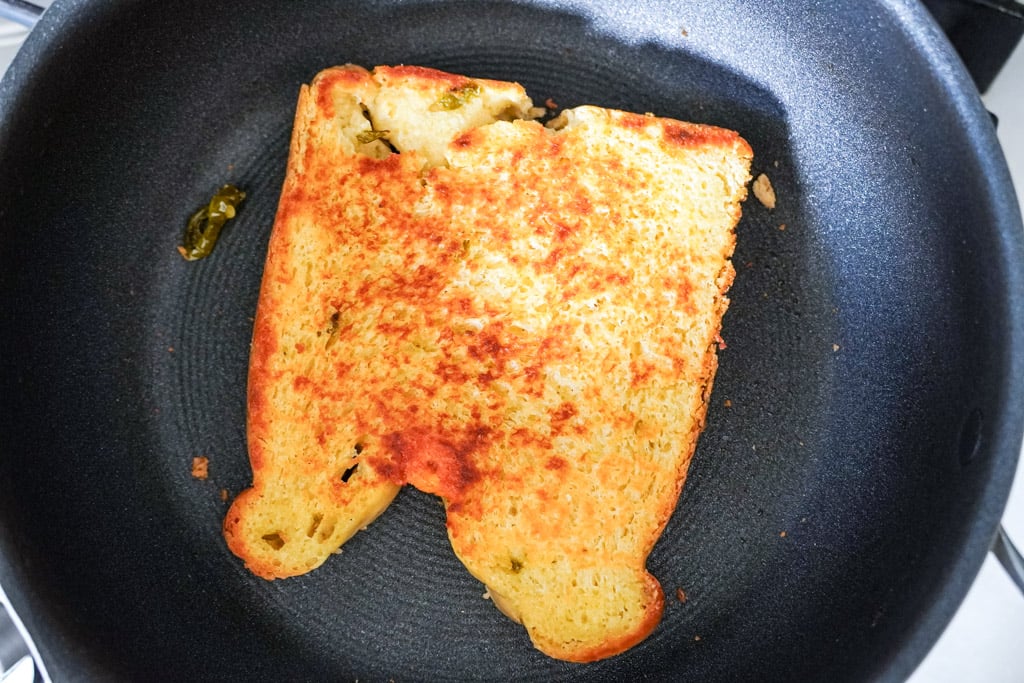 toasting a piece of jalapeno cheddar bread in a skillet
