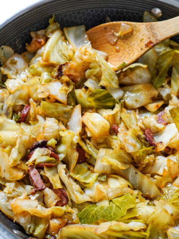 fried cabbage in a pot with a wooden spoon