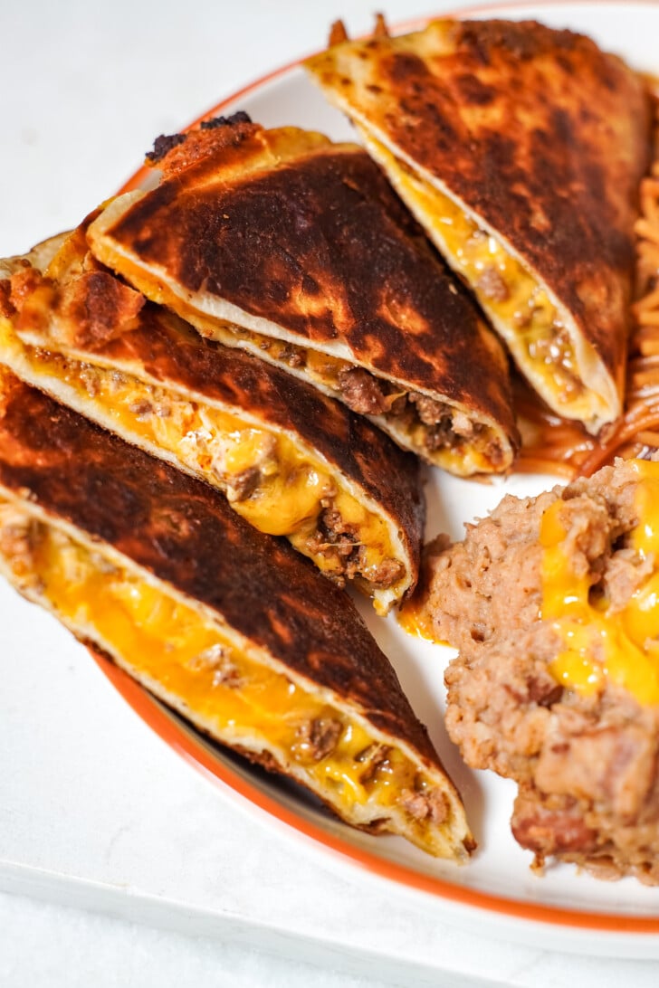 a close up of beef and cheese quesadillas cut open on a plate