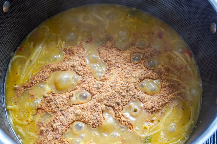 seasoning sprinkled in a pot of pasta