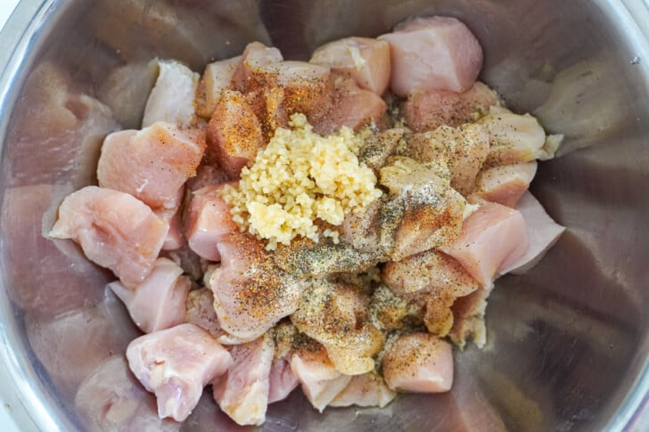 chicken breast chunks in a bowl with seasoning