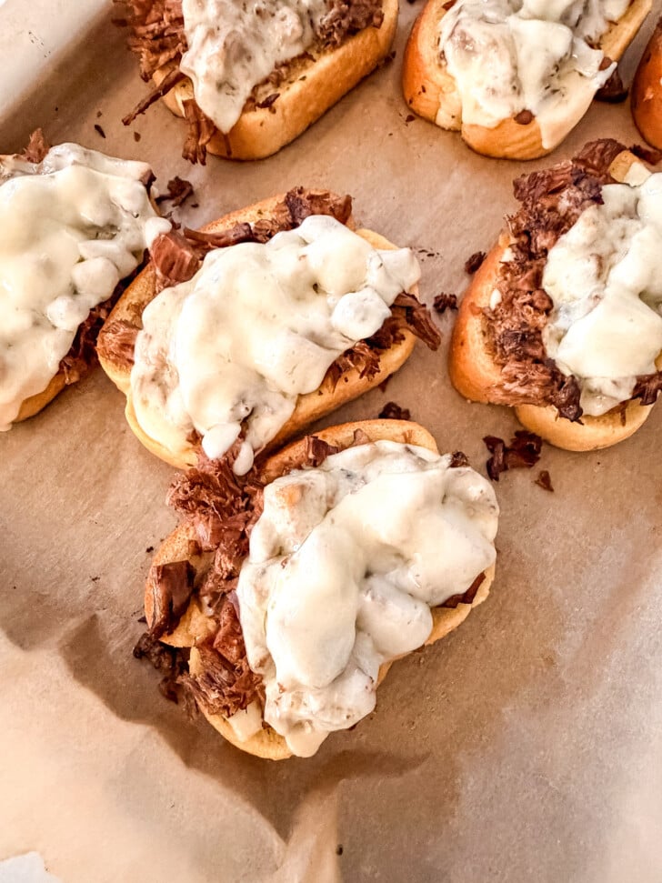 open faced roast beef sandwiches on a sheet pan