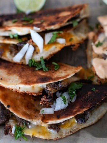 steak tacos on a tray with onion and cilantro