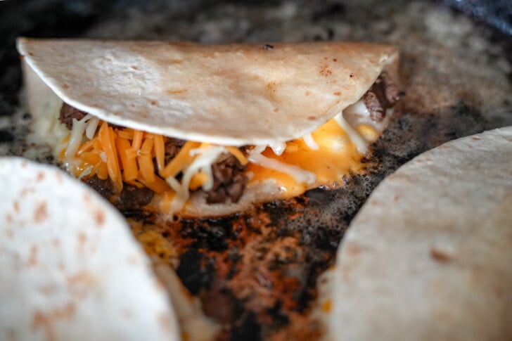 steak tacos cooking in a skillet
