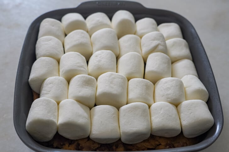 marshmallows layered on top of cookie dough for a s'mores cookie skillet