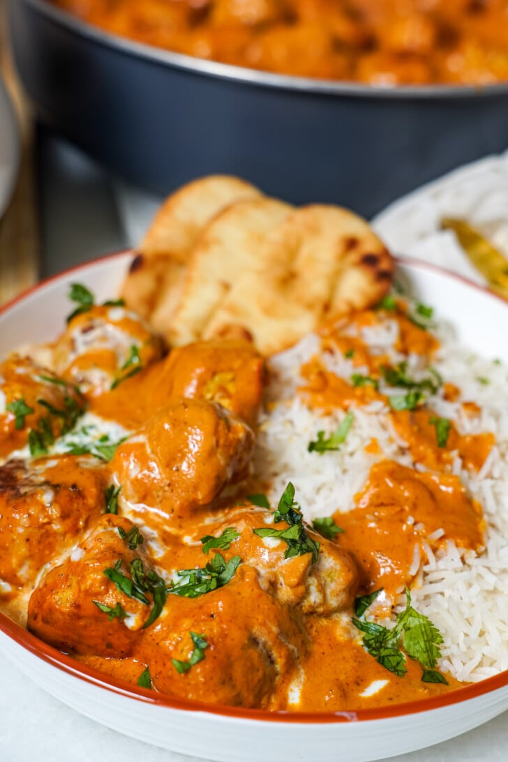 butter chicken meatballs in a bowl with white rice