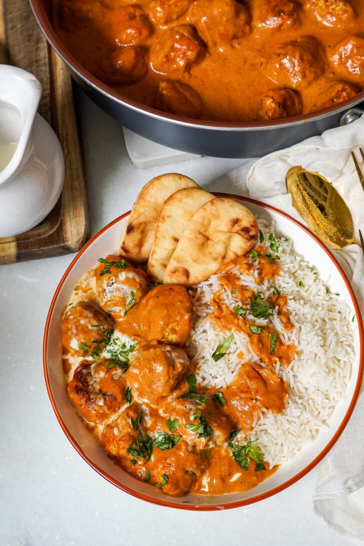 butter chicken meatballs in a bowl with white rice
