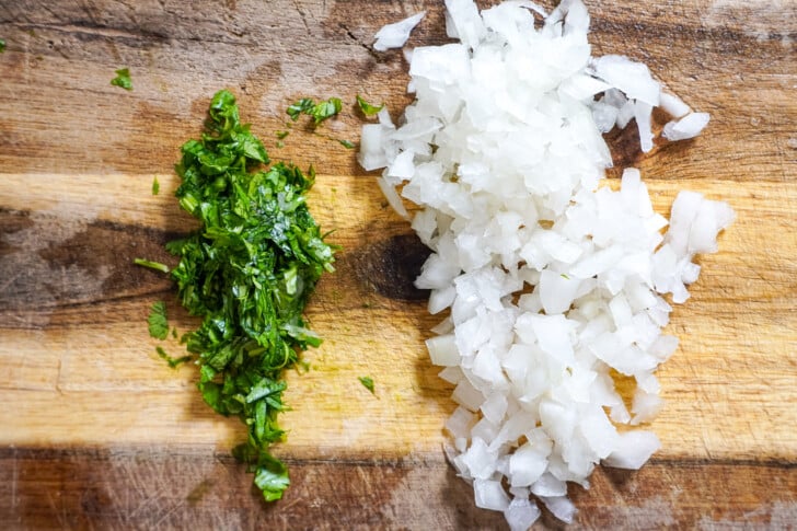 onions and cilantro diced on a cutting board