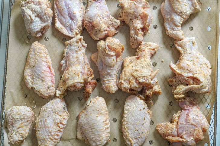 seasoned raw chicken wings on an air fryer tray